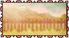 A stamp of a pasture fence with mountains in the distance.